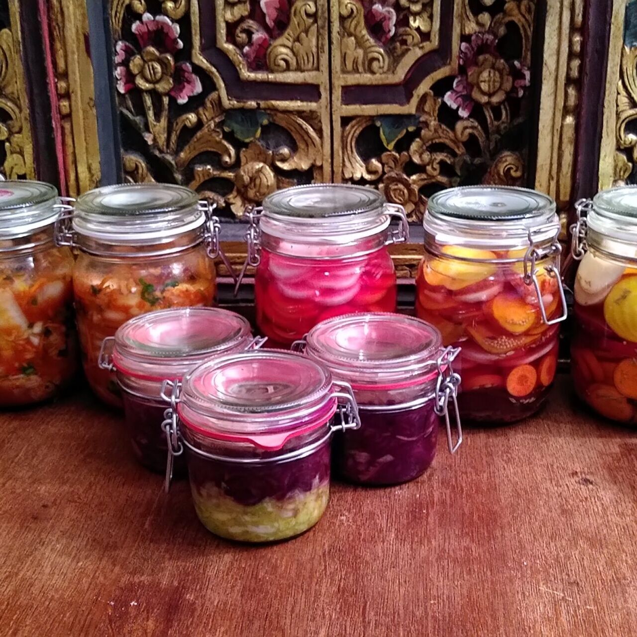 Een rij weckpotjes met gefermenteerde groenten, klaar om te proeven en te ontdekken hoe lekker fermenteren kan zijn.